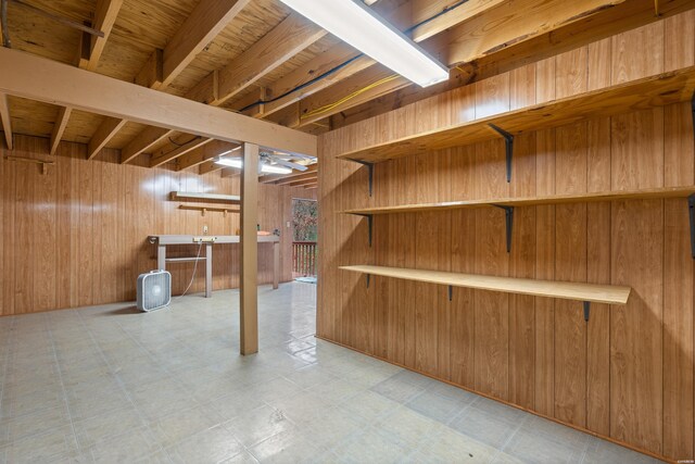 finished below grade area featuring wooden walls and light floors