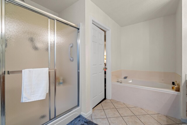 full bathroom featuring a shower stall, a bath, and tile patterned floors