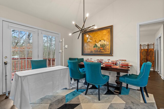 dining area with a chandelier, vaulted ceiling, and wood finished floors