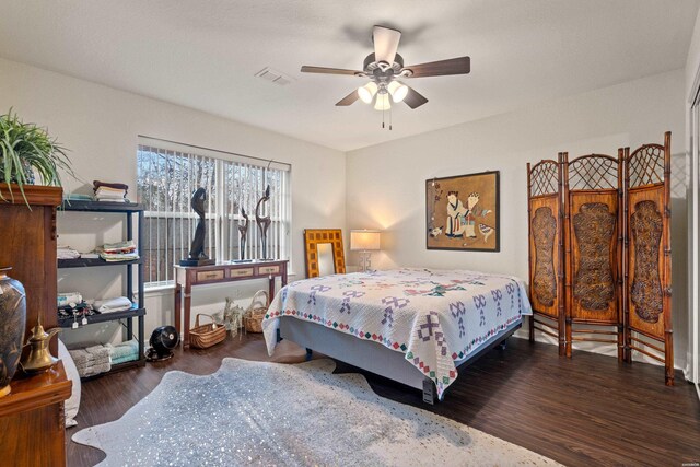 bedroom featuring a ceiling fan, visible vents, and dark wood-type flooring