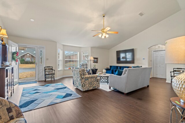 living room featuring dark wood-style floors, arched walkways, visible vents, vaulted ceiling, and baseboards