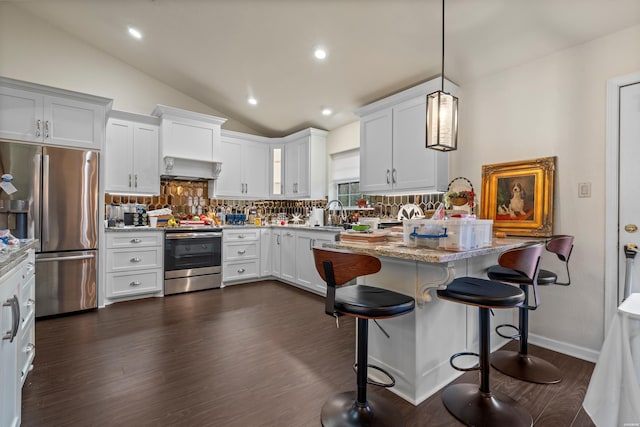 kitchen featuring stainless steel appliances, light stone counters, white cabinetry, and pendant lighting