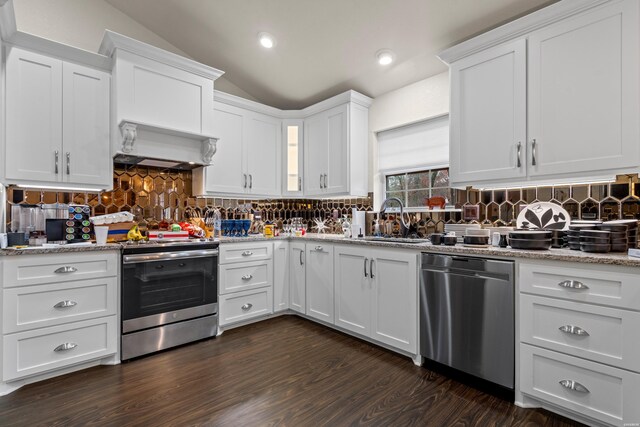 kitchen featuring stainless steel appliances, premium range hood, a sink, white cabinets, and vaulted ceiling