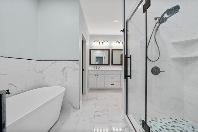 full bath featuring marble finish floor, vanity, a freestanding tub, and a marble finish shower