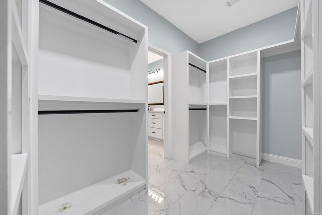 spacious closet featuring marble finish floor