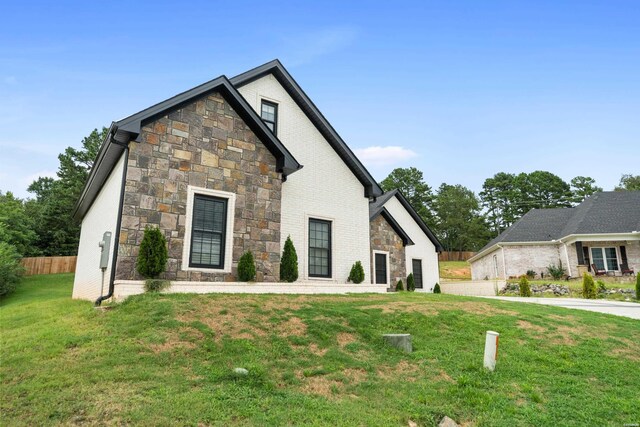 view of front of home with a front yard and fence