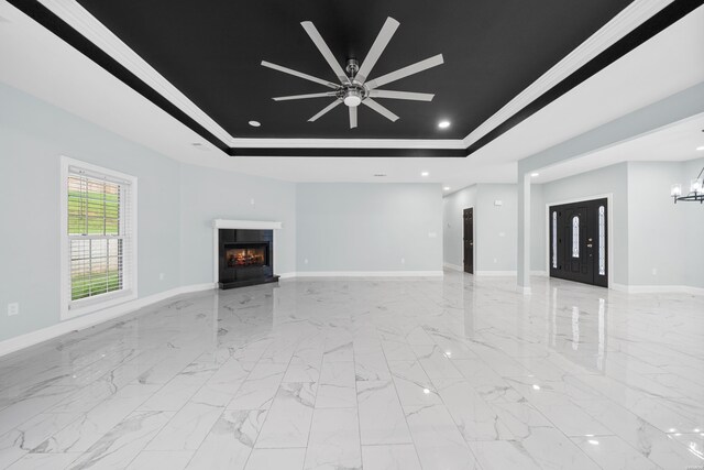 unfurnished living room featuring a warm lit fireplace, baseboards, a tray ceiling, and ornamental molding