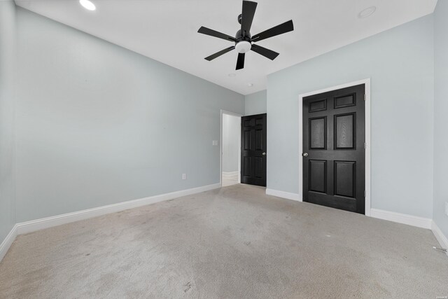 unfurnished bedroom with carpet floors, a ceiling fan, and baseboards