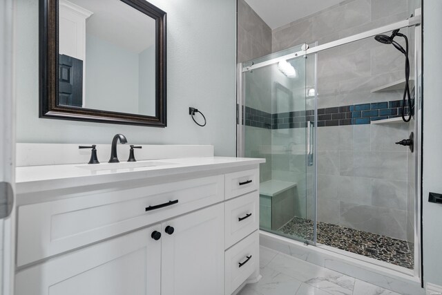 bathroom featuring a stall shower, marble finish floor, and vanity