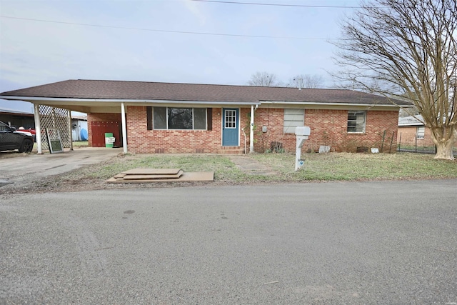 single story home with brick siding, a shingled roof, crawl space, an attached carport, and driveway