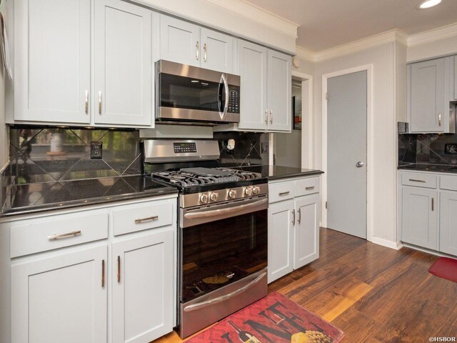 9925 Echo Valley Ct, Little Rock, AR 72227 - kitchen with stainless steel appliances, decorative backsplash, crown molding, dark wood-style floors, and recessed lighting