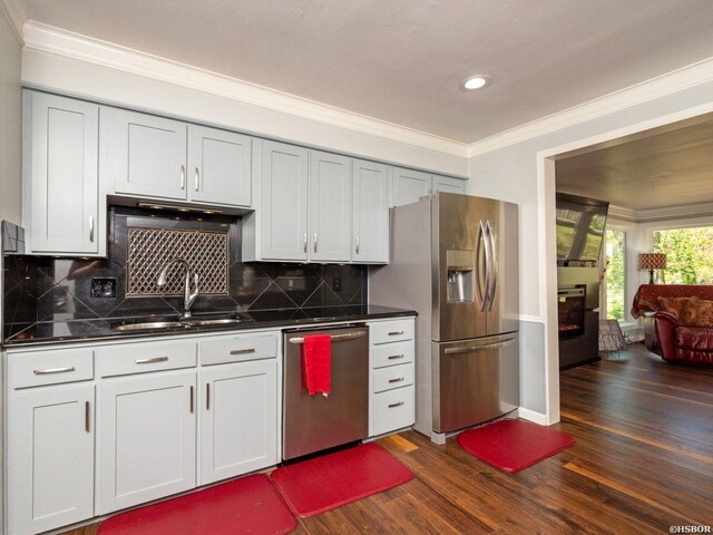 9925 Echo Valley Ct, Little Rock, AR 72227 - kitchen with appliances with stainless steel finishes, a sink, dark countertops, crown molding, and dark wood-style flooring