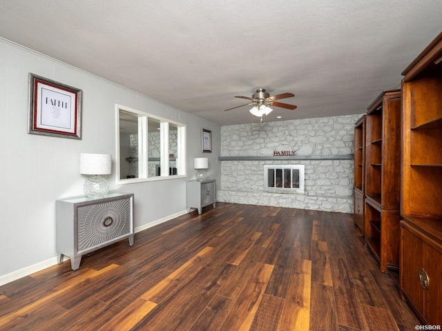 9925 Echo Valley Ct, Little Rock, AR 72227 - unfurnished living room with ceiling fan, dark wood-type flooring, a stone fireplace, and baseboards
