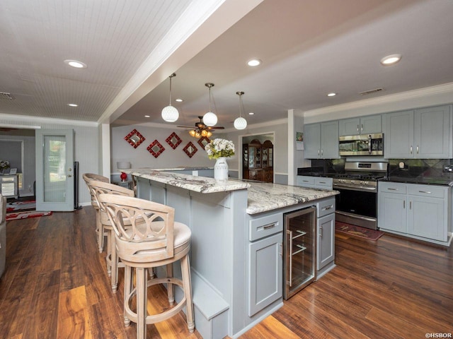 9925 Echo Valley Ct, Little Rock, AR 72227 - kitchen with stainless steel appliances, beverage cooler, dark wood-type flooring, a center island, and ornamental molding