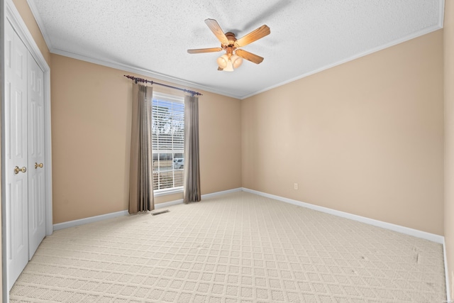 unfurnished room featuring ornamental molding, light colored carpet, visible vents, and baseboards