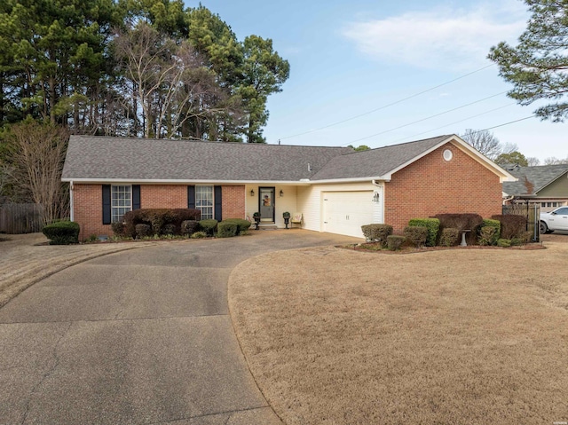 ranch-style home with driveway, a garage, a front lawn, and brick siding