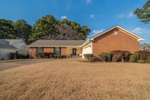 ranch-style house with a garage, driveway, a front lawn, and brick siding