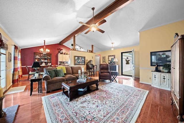 living area featuring lofted ceiling with beams, a textured ceiling, and wood finished floors