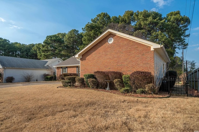 view of home's exterior with fence, a lawn, and brick siding