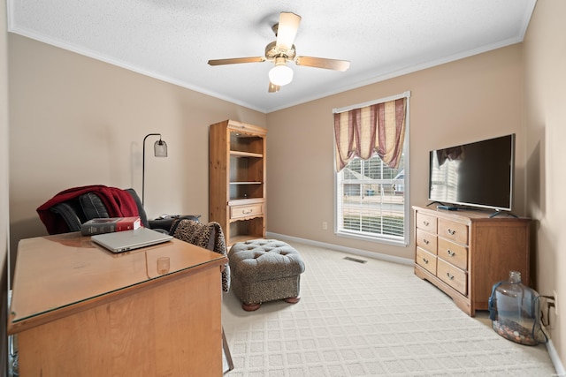 home office with ornamental molding, a ceiling fan, and light colored carpet