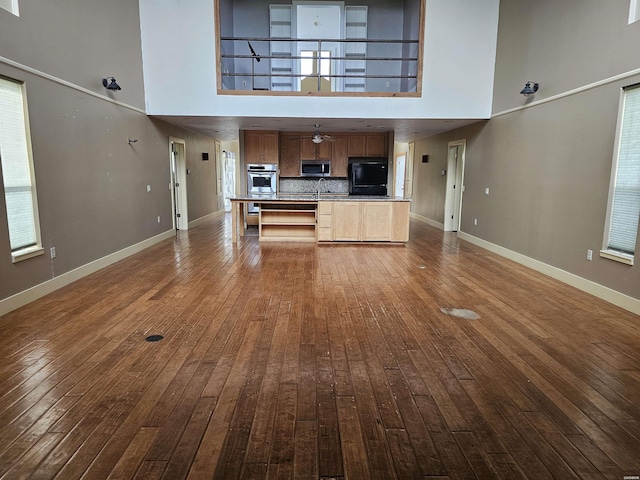 161 Funderburg Rd, Mineral Springs, AR 71851 - unfurnished living room with a high ceiling, dark wood finished floors, and baseboards