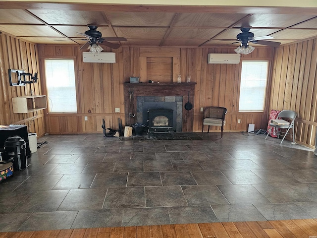 161 Funderburg Rd, Mineral Springs, AR 71851 - living room featuring a wood stove, ceiling fan, a wall mounted AC, and wood walls
