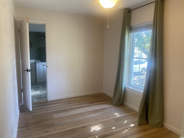 unfurnished room with light wood-type flooring, a wealth of natural light, and baseboards