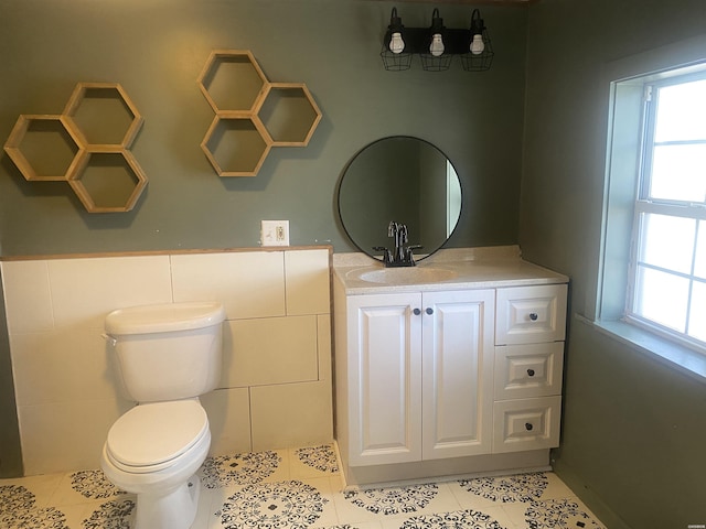 half bath featuring vanity, toilet, and tile patterned floors