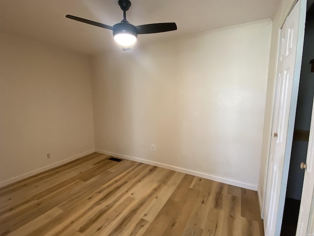 spare room featuring baseboards, ceiling fan, and light wood-style floors