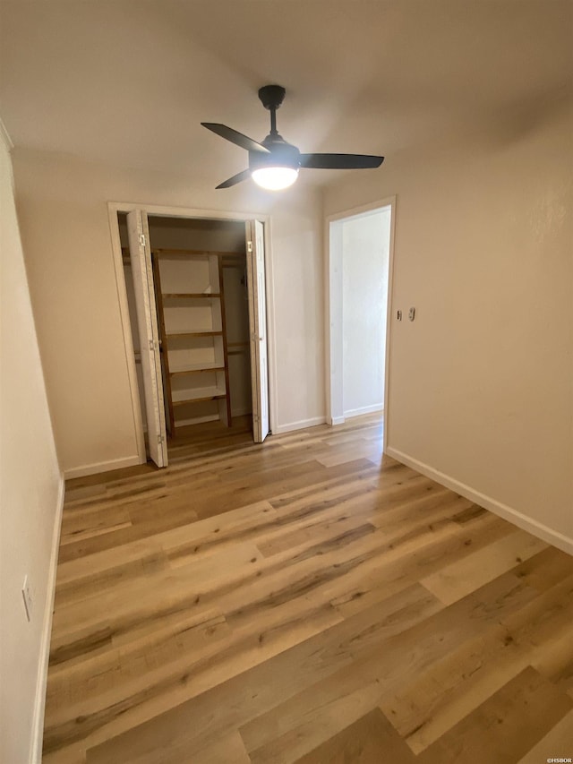 unfurnished bedroom with a ceiling fan, light wood-style flooring, baseboards, and a closet