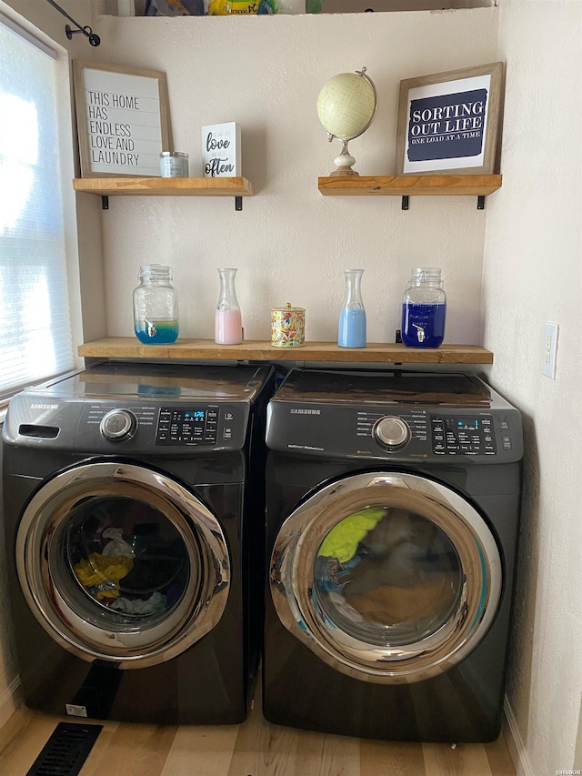 clothes washing area featuring a wealth of natural light, laundry area, and independent washer and dryer