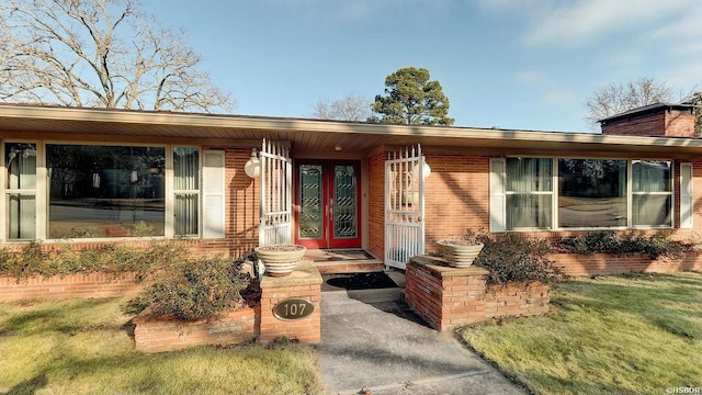 view of front of house with a front yard and brick siding