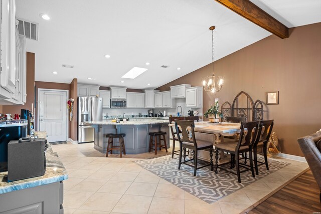 dining room with light tile patterned floors, visible vents, recessed lighting, and vaulted ceiling with beams