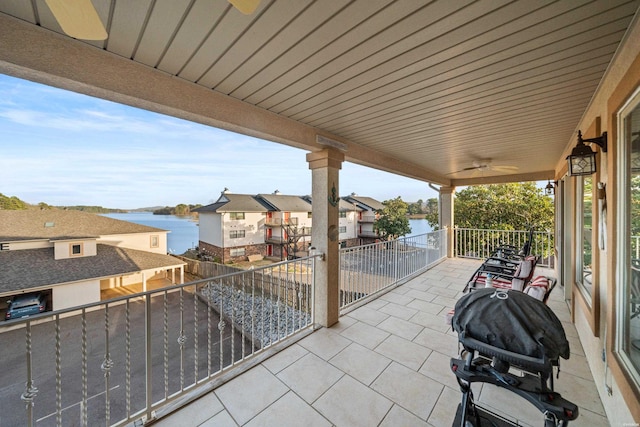 view of patio with a balcony, a water view, and grilling area