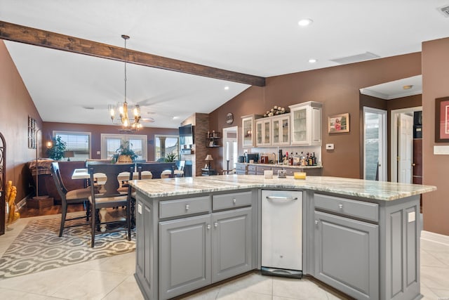 kitchen featuring visible vents, vaulted ceiling with beams, a kitchen island with sink, gray cabinetry, and a chandelier