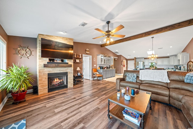 living room featuring visible vents, light wood-style flooring, ceiling fan with notable chandelier, lofted ceiling with beams, and a fireplace