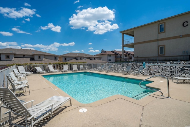 community pool featuring a patio and fence