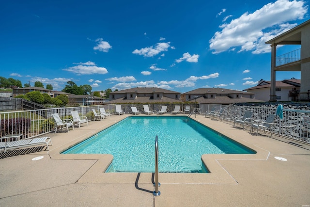 community pool with fence and a patio area