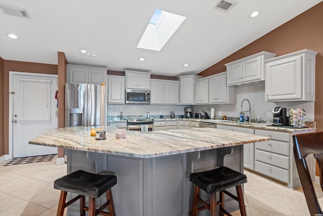 kitchen featuring a sink, stainless steel appliances, visible vents, and light tile patterned floors