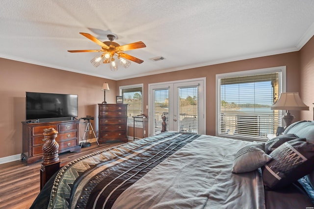 bedroom featuring visible vents, crown molding, french doors, wood finished floors, and access to outside