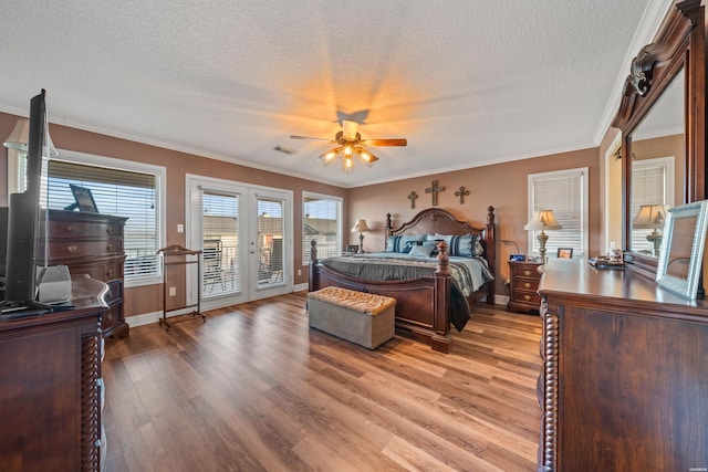 bedroom with access to exterior, multiple windows, and light wood finished floors