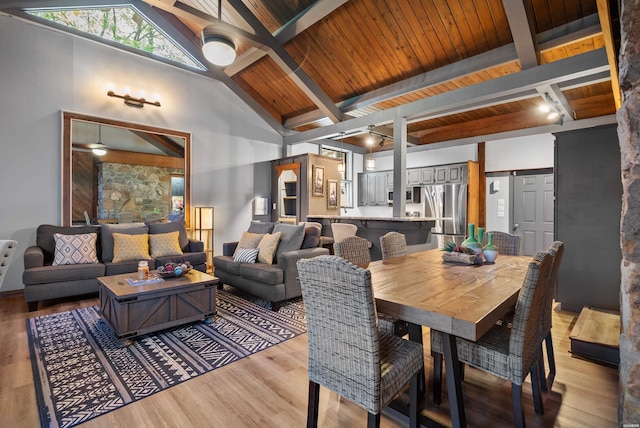 dining area with light wood-type flooring, beamed ceiling, wooden ceiling, and high vaulted ceiling