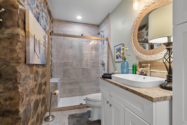 full bathroom featuring a stall shower, vanity, and toilet