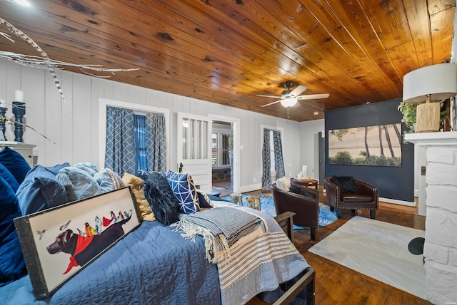 bedroom with dark wood-style floors, a fireplace, ceiling fan, wooden ceiling, and baseboards