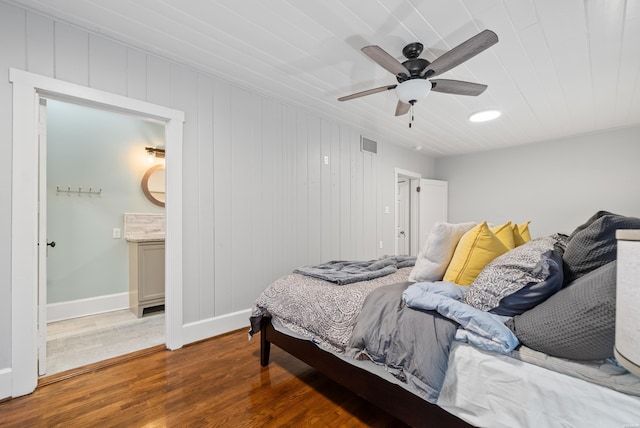 bedroom featuring baseboards, visible vents, dark wood finished floors, ceiling fan, and ensuite bathroom