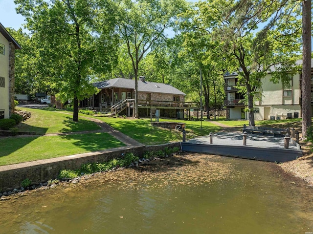 view of home's community with a yard and a water view