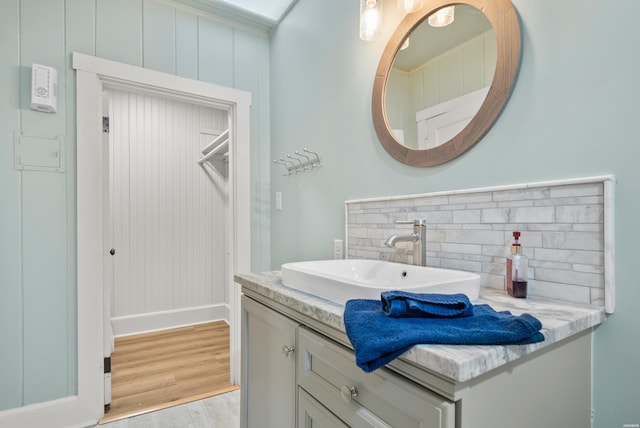 bathroom featuring backsplash, wood finished floors, and vanity