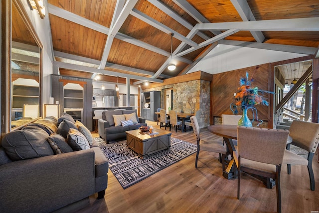 living room featuring lofted ceiling with beams, wooden ceiling, wooden walls, and wood finished floors