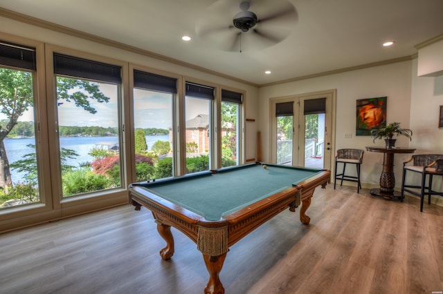 game room with recessed lighting, pool table, a water view, wood finished floors, and ornamental molding