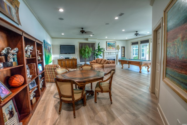 dining area with a fireplace, recessed lighting, visible vents, light wood-style flooring, and ornamental molding